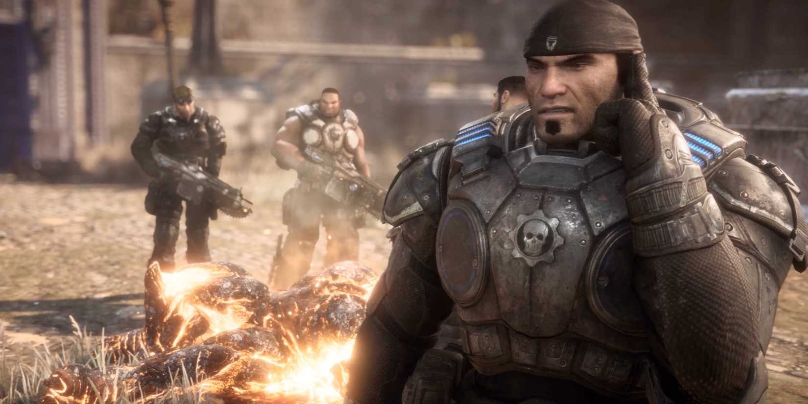 Delta Squad standing around a burning Berserker corpse in Gears of War Reloaded.