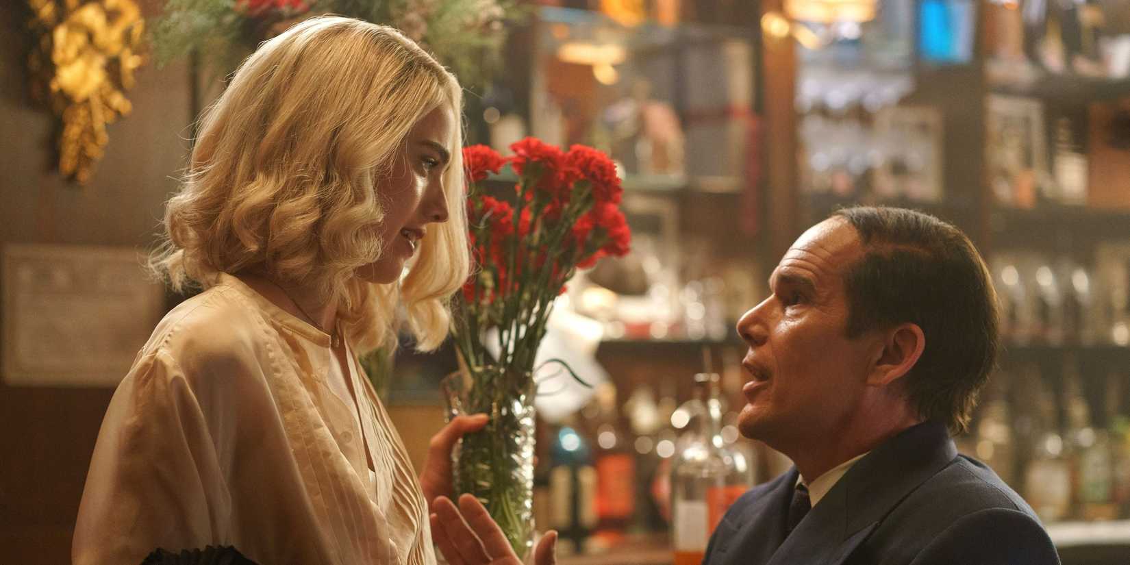 Ethan Hawke gazing up at Margaret Qualley, who stands next to him, in Blue Moon