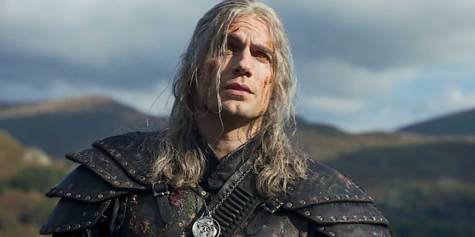 Henry Cavill como Geralt de Rivia olhando para cima com montanhas atrás dele no Witcher