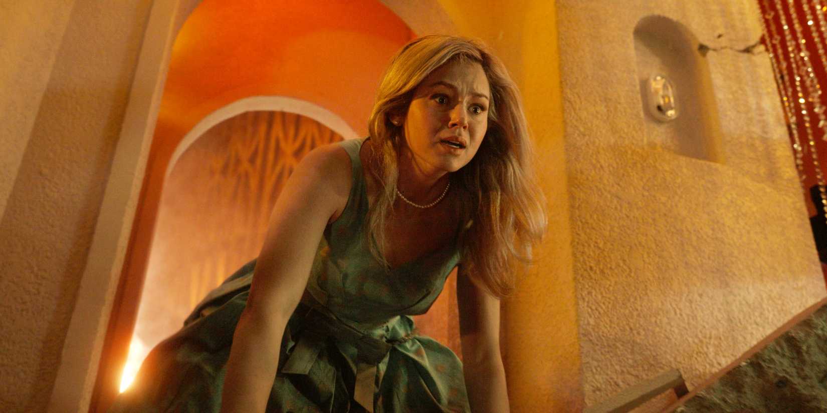 Iris de mãos e joelhos olhando para algo com horror no restaurante Skyview em Final Destination Bloodlines