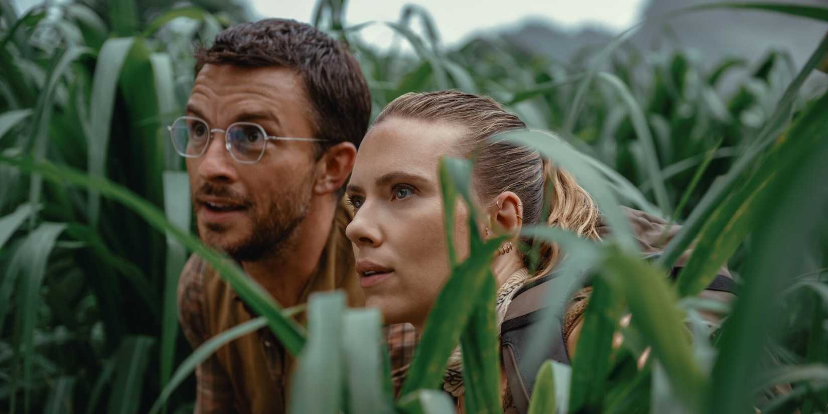 Jonathan Bailey and Scarlett Johansson staring at a dinosaur in Jurᴀssic World Rebirth