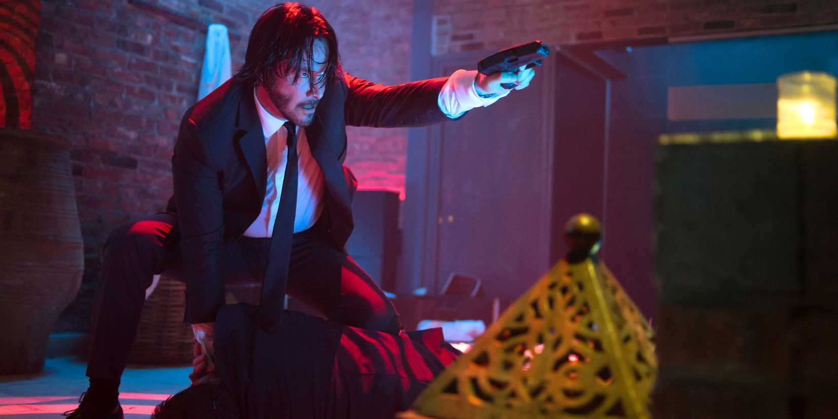Keanu Reeves as John Wick aiming a gun in the first movie