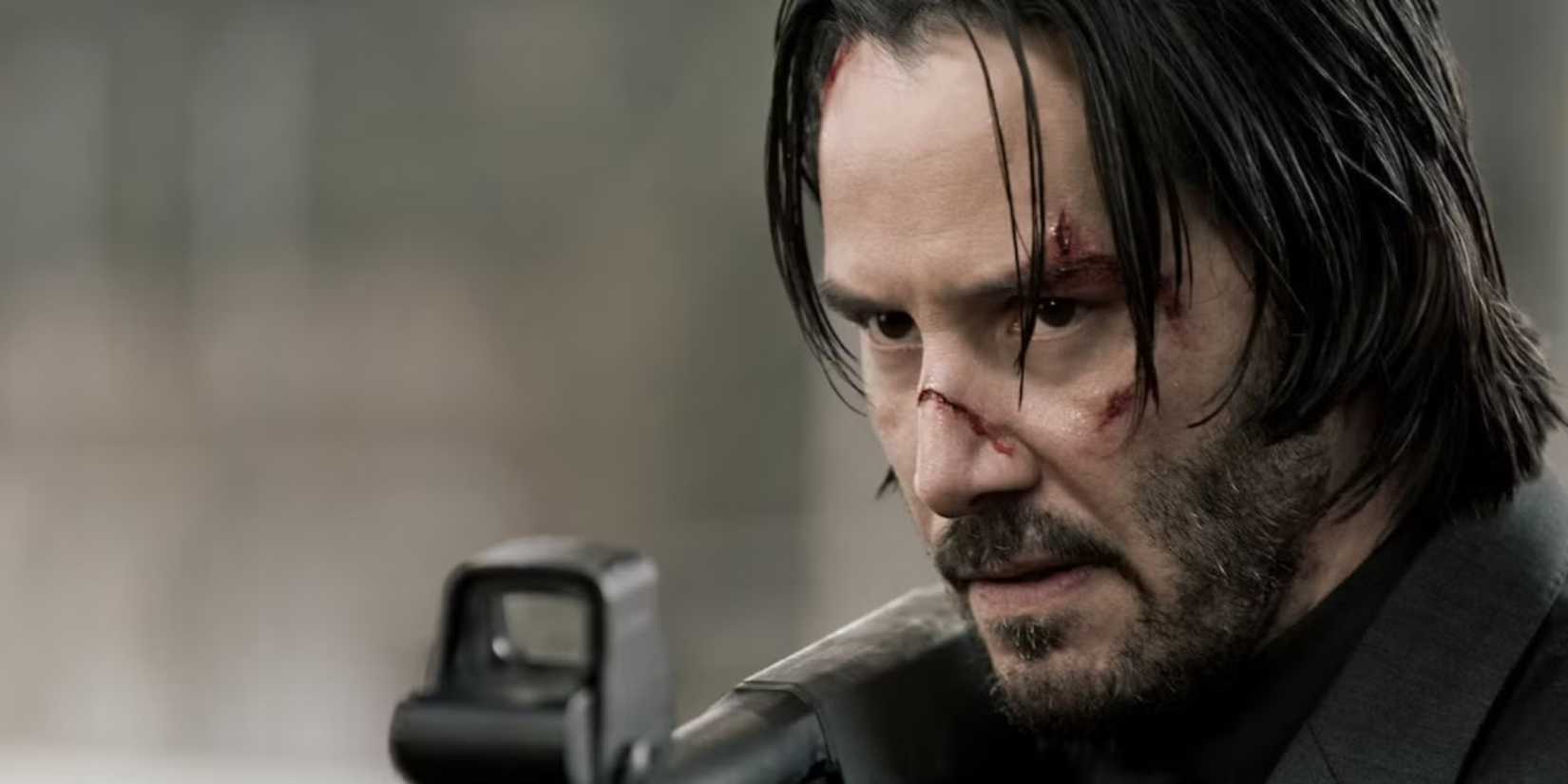 Keanu Reeves as John Wick, pointing a gun