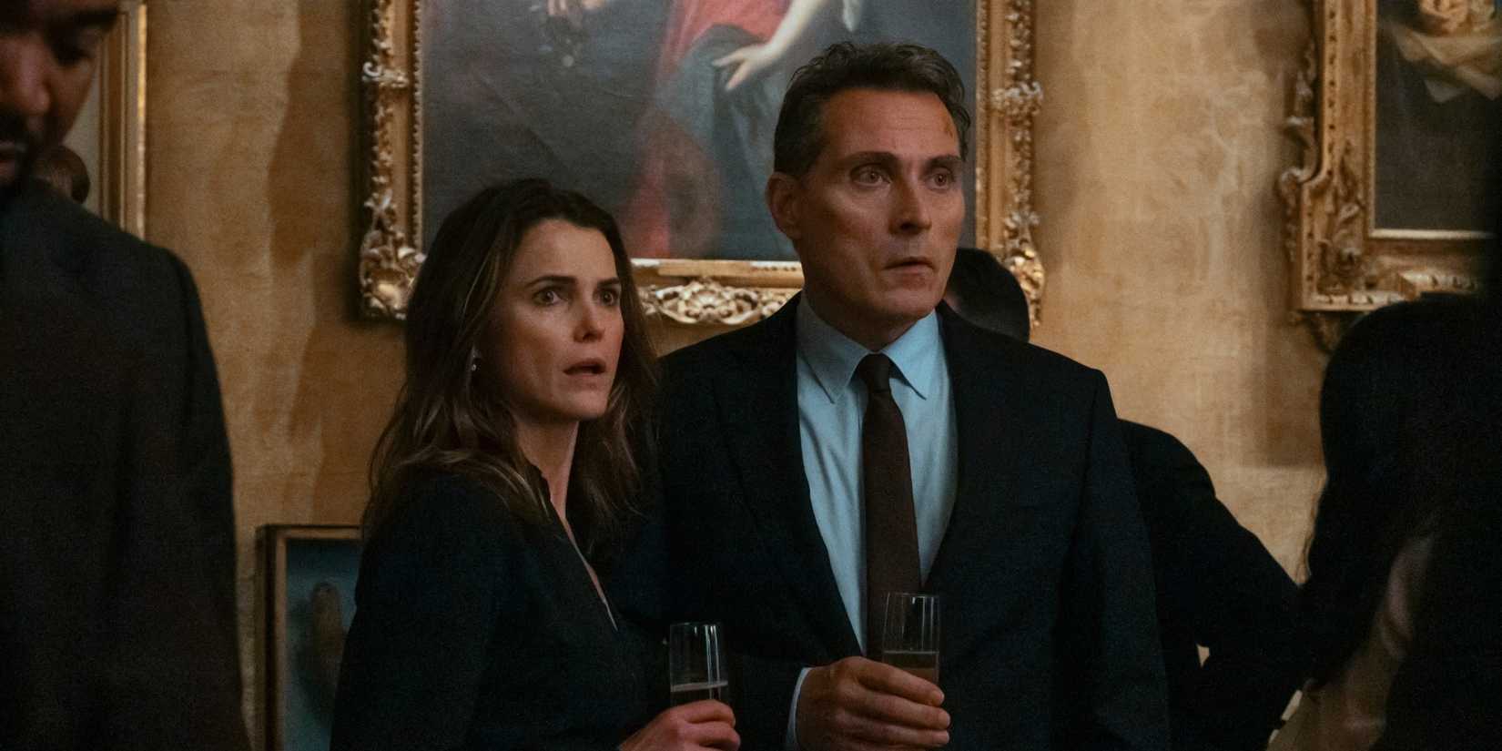 Netflix's 12-Year Political Thriller Struggle Ends with The Diplomat Season 3 Keri Russell and Rufus Sewell looking shocked while standing close to one another in The Diplomat