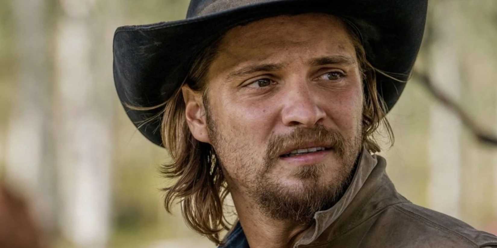 Luke Grimes In Yellowstone with pained expression, in hat and shirt
