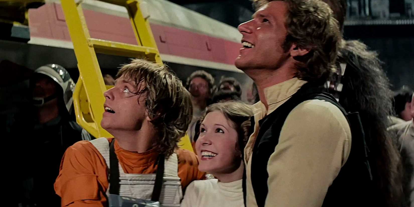 Luke Leia y Han Solo tomados de la mano y sonriendo al final de Star Wars: Una nueva esperanza