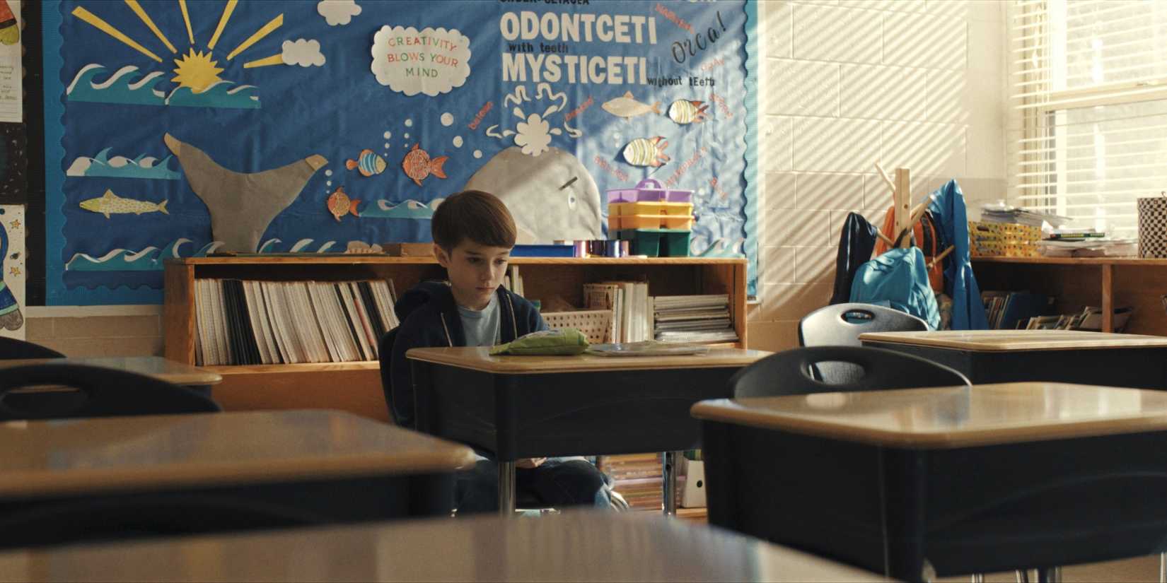 Alex sits in the classroom alone in Weapons