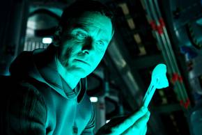 Michael Fassbender examining something in Alien Convenant