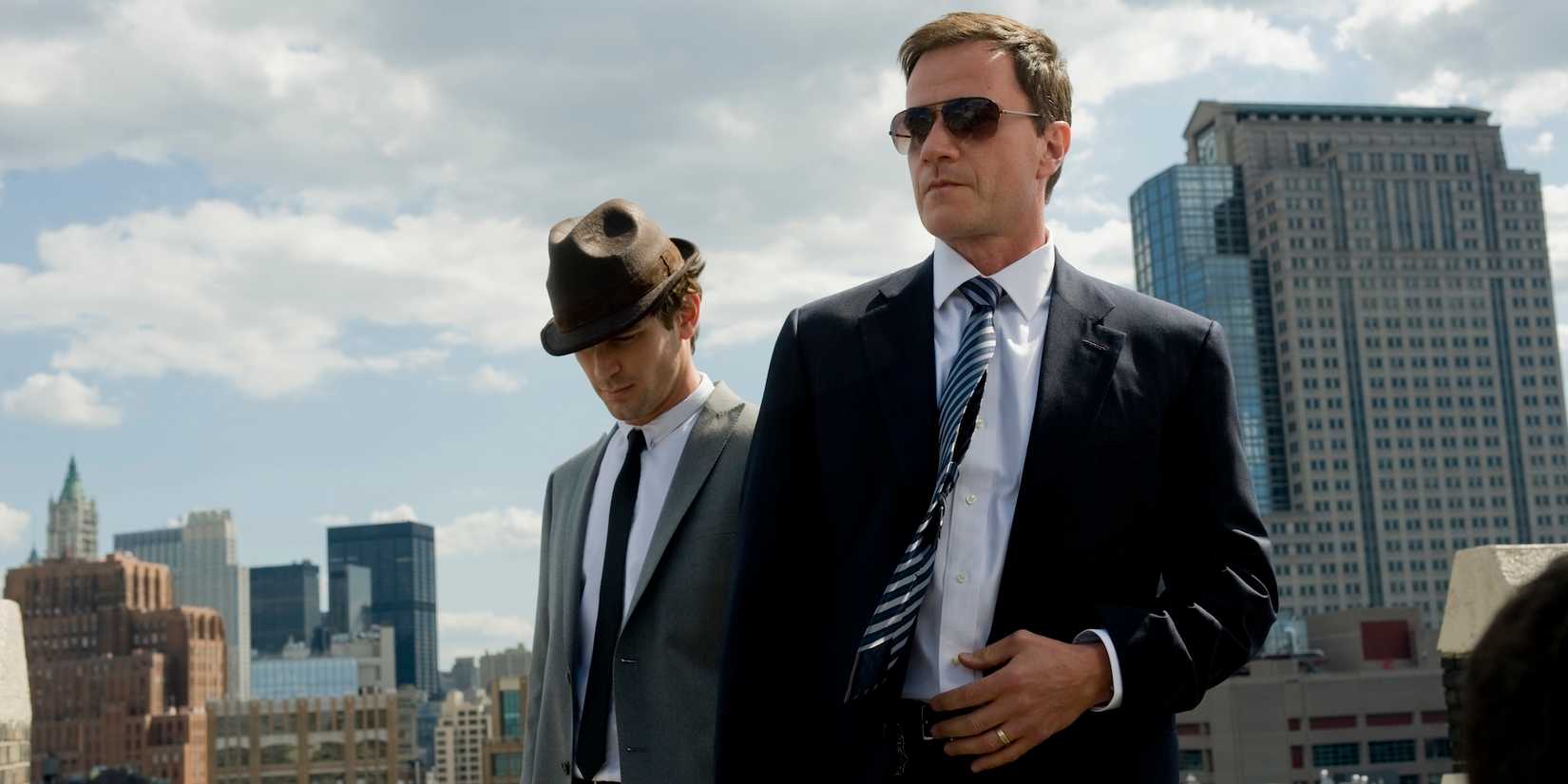 Neal and Peter stand on the roof of a New York City building in White Collar