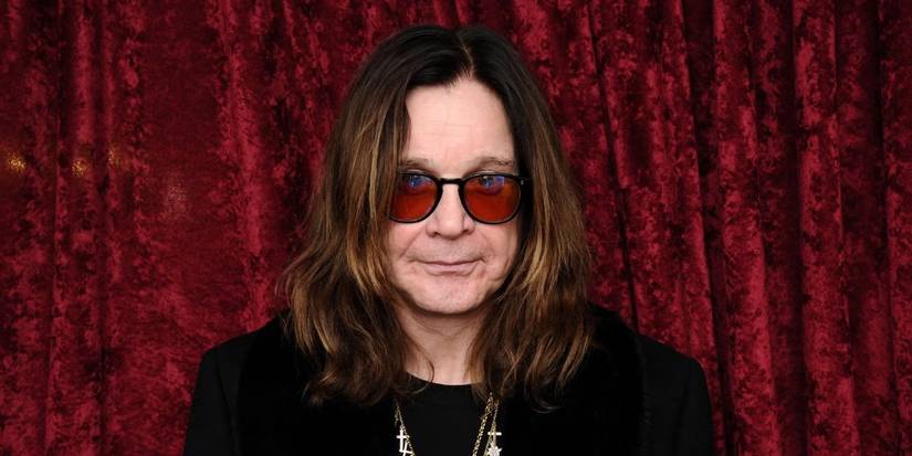 Ozzy Osbourne in front of red curtain
