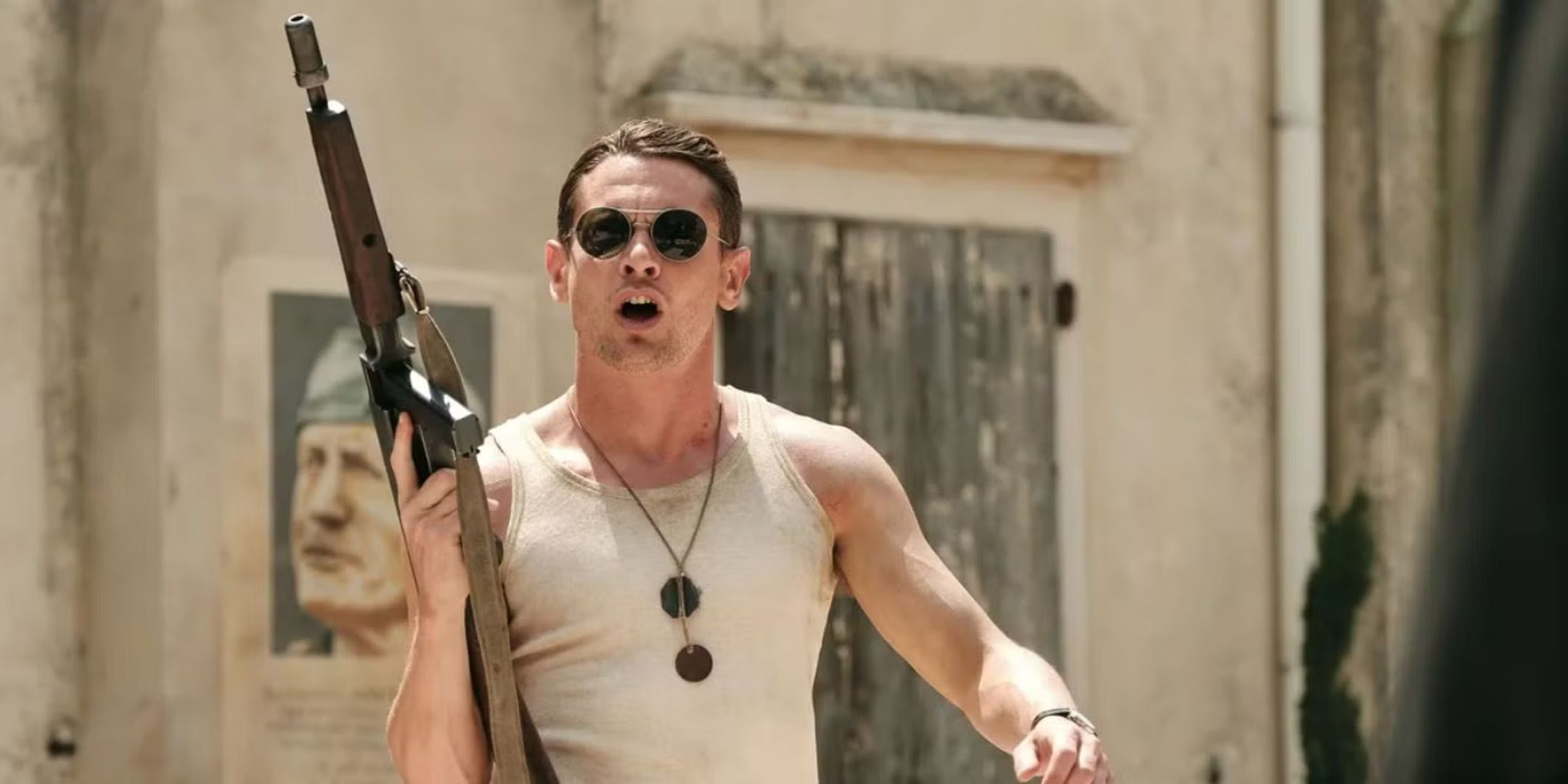 Paddy Mayne (Jack O'Connell) walking and holding up a gun while shouting in SAS Rogue Heroes. (1)
