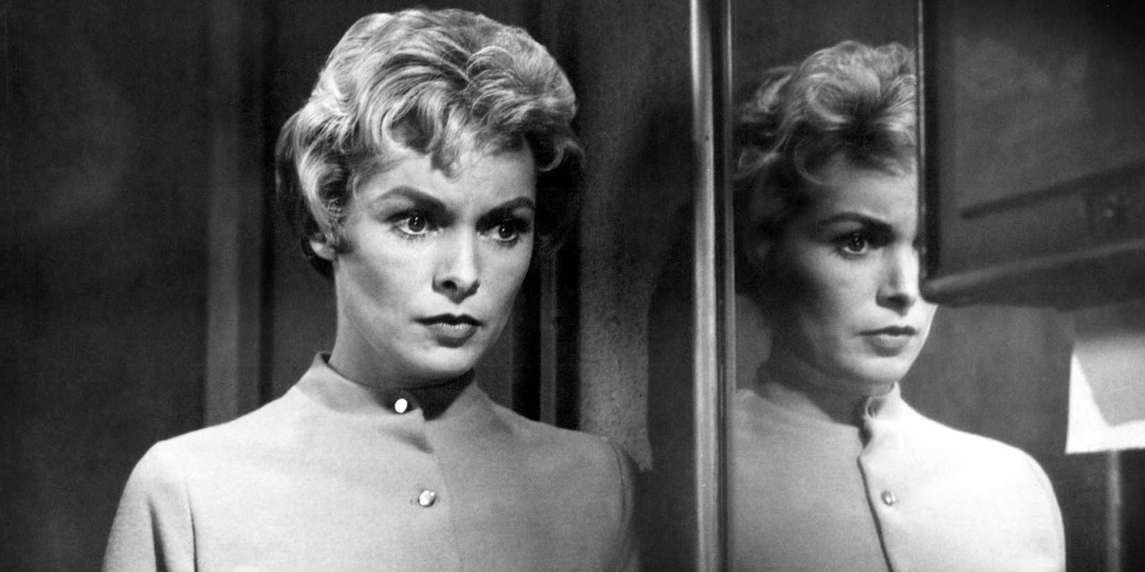 Marion looks concerned while standing near a mirror in Psycho