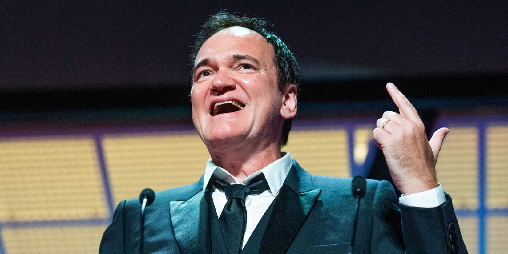 Quentin Tarantino talks animatedly onstage at Cannes Film Festival