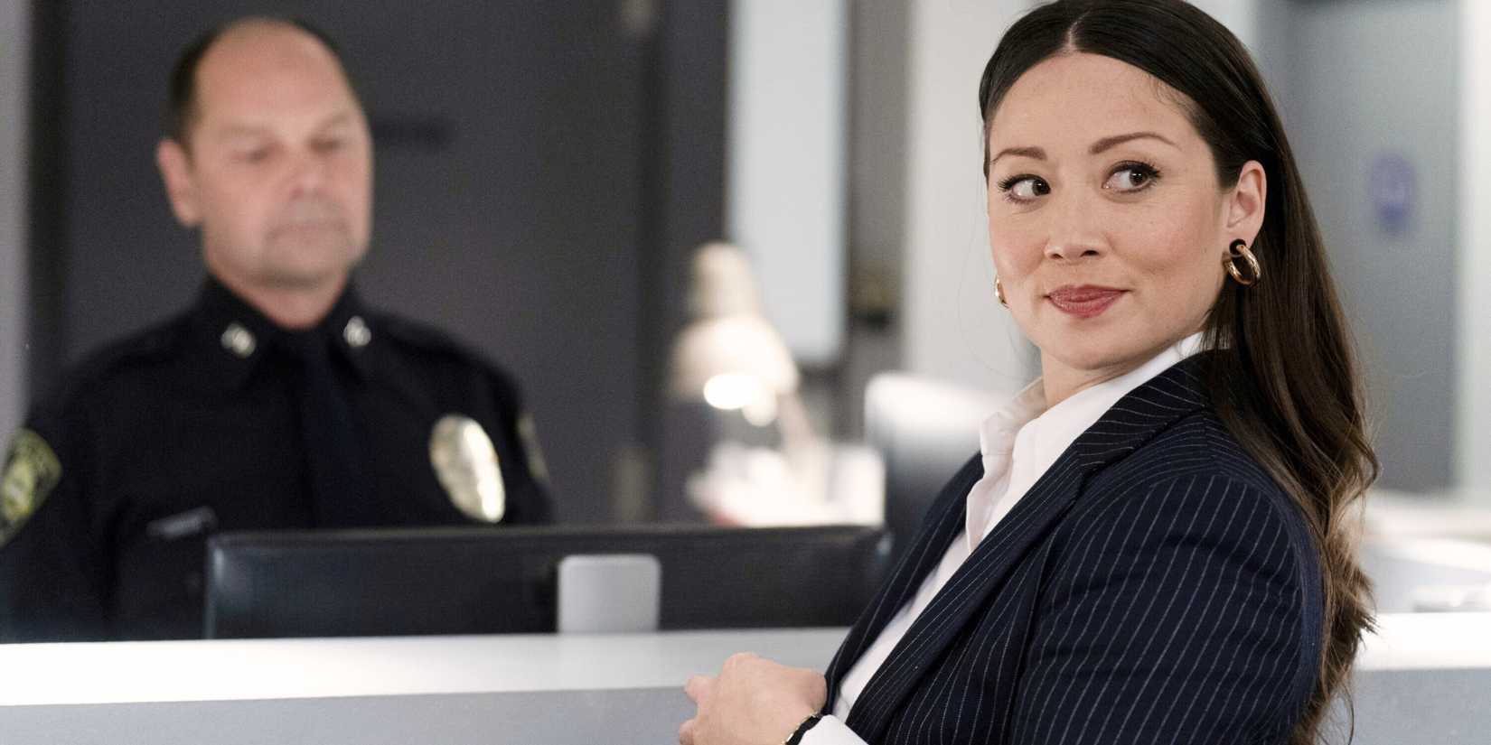 Reenie Green (Fiona Rene) smiling over her shoulder in a police station in the Tracker pilot episode