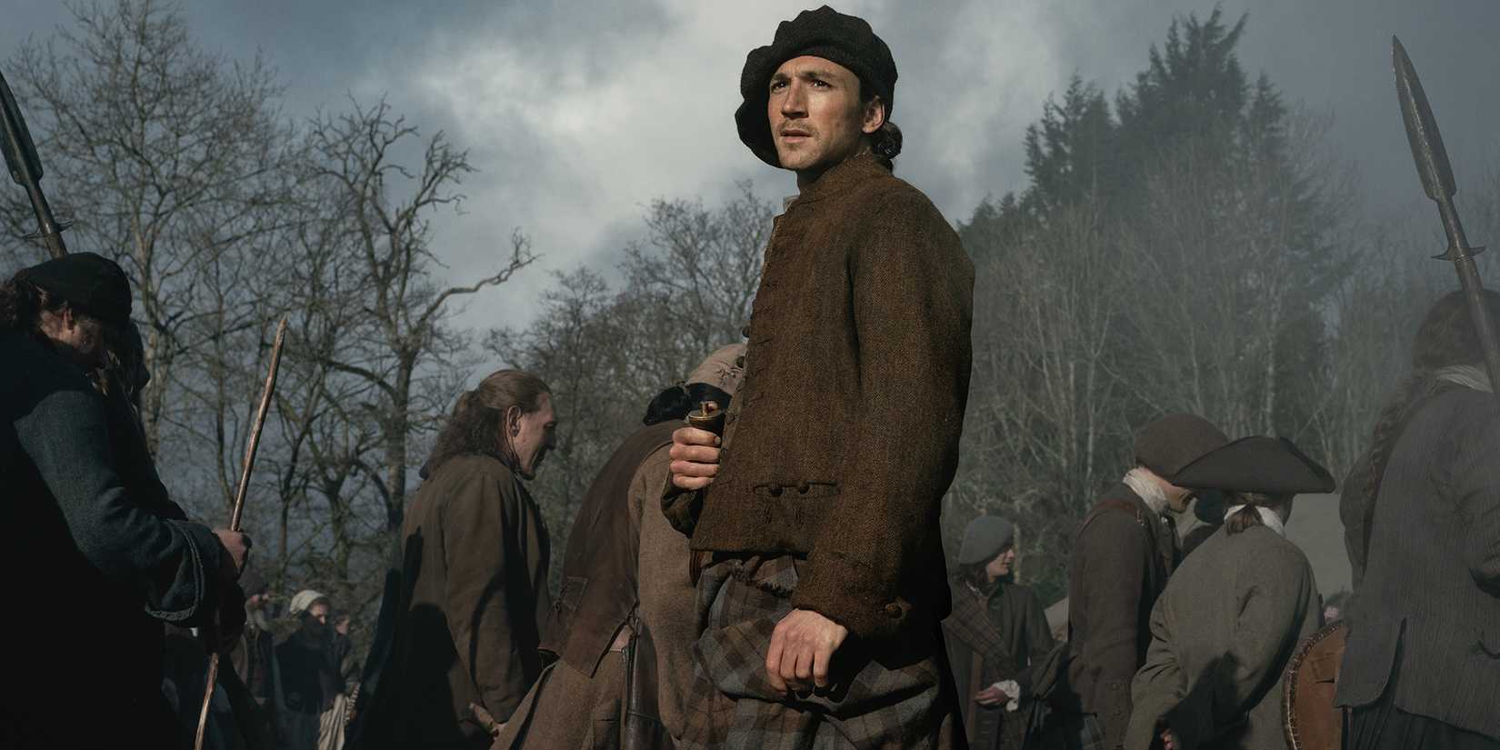 Rory Alexander's Murtagh looking into the distance while standing in a crowd in Outlander: Blood of My Blood