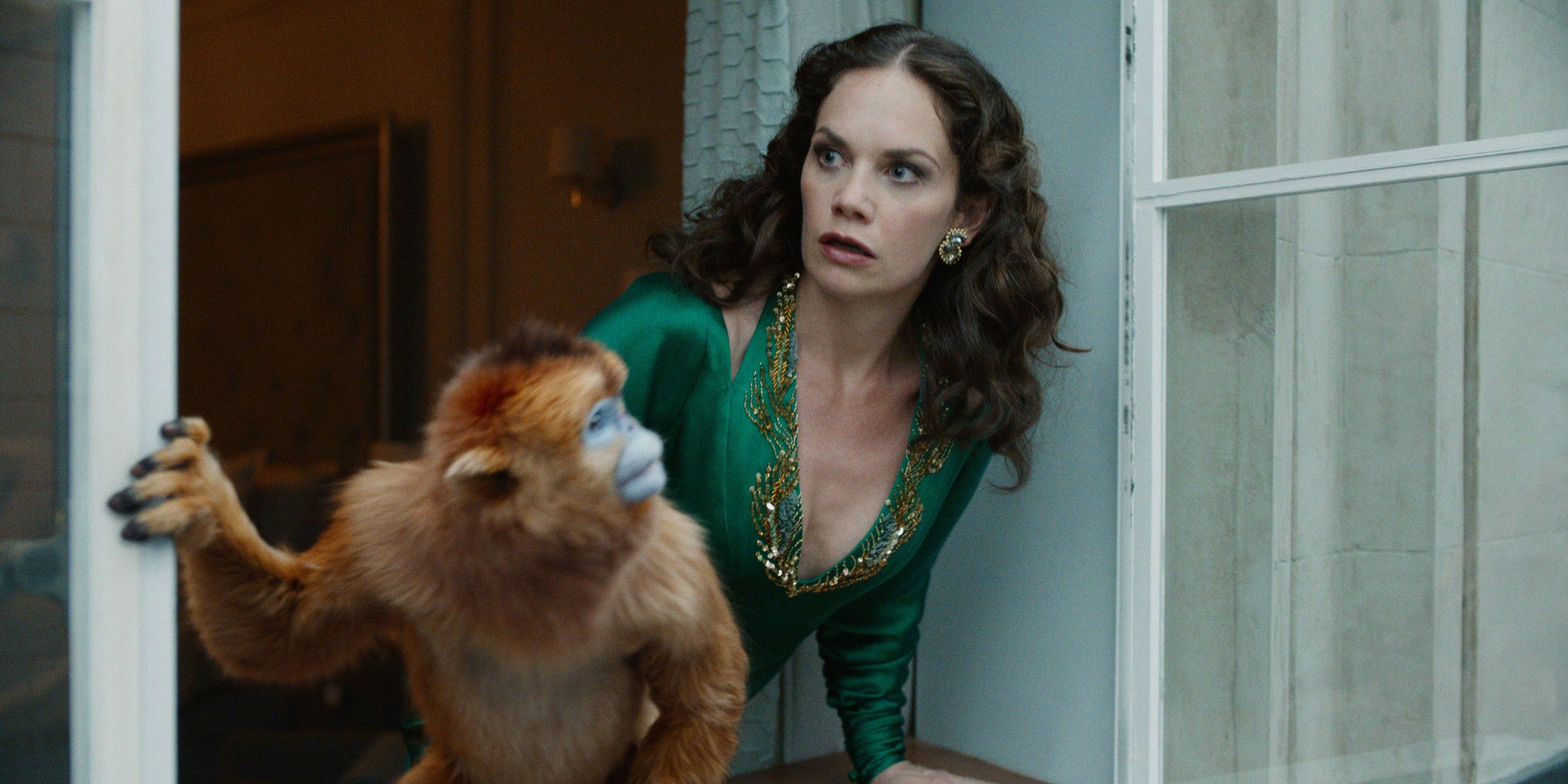 Ruth Wilson as Mrs Coulter looking around a corner with her Daemon in HBO's His Dark Materials