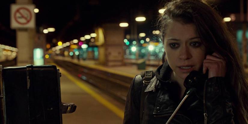 Sarah on the phone on a railway platform in Orphan Black