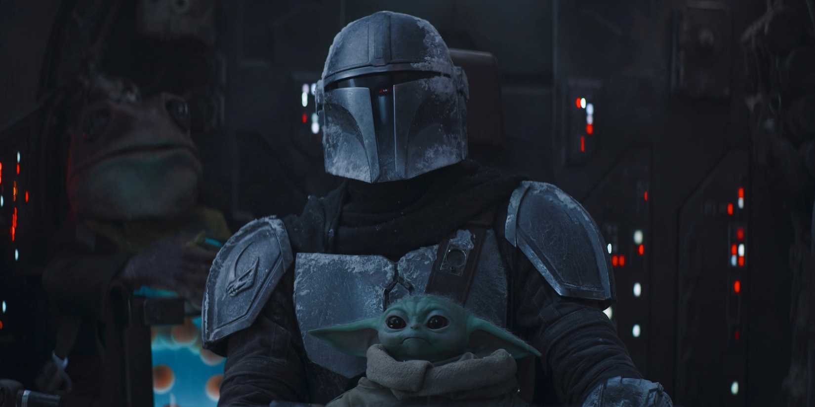 Din Djarin holds Grogu on his lap in the Razor Crest's cockpit, with Frog Lady sitting behind them.