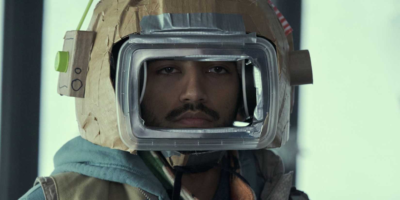 Frank (Nabhaan Rizwan) staring through an isolation suit in STATION ELEVEN ‘Goodbye My Damaged Home', (Season 1, ep. 107, aired Dec. 30, 2021) (1)
