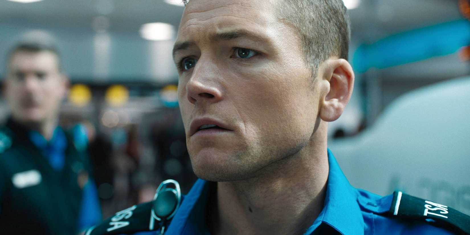Taron Egerton is looking concerned while looking at his screen in Carry On