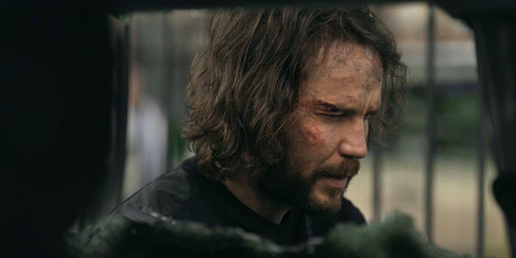 Taylor Kitsch as Ben Edwards side profile with blood on his face in The Terminal List Dark Wolf