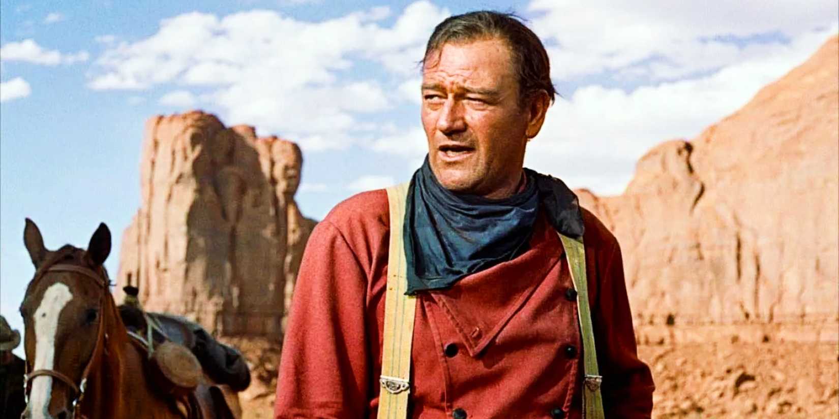 Ethan Edwards looks off to the side after taking off his hat in The Searchers