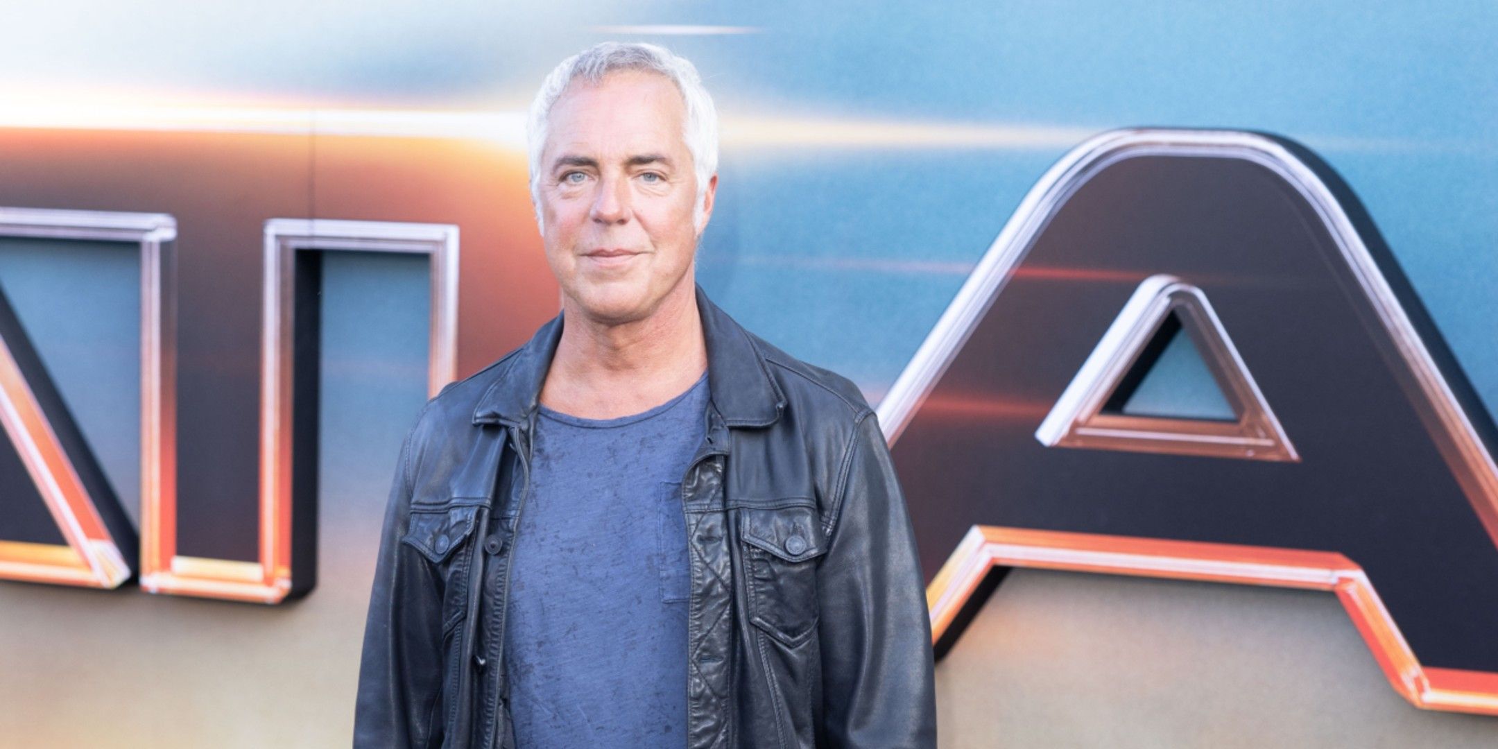 Titus Welliver smirks while standing on the red carpet for Atlas