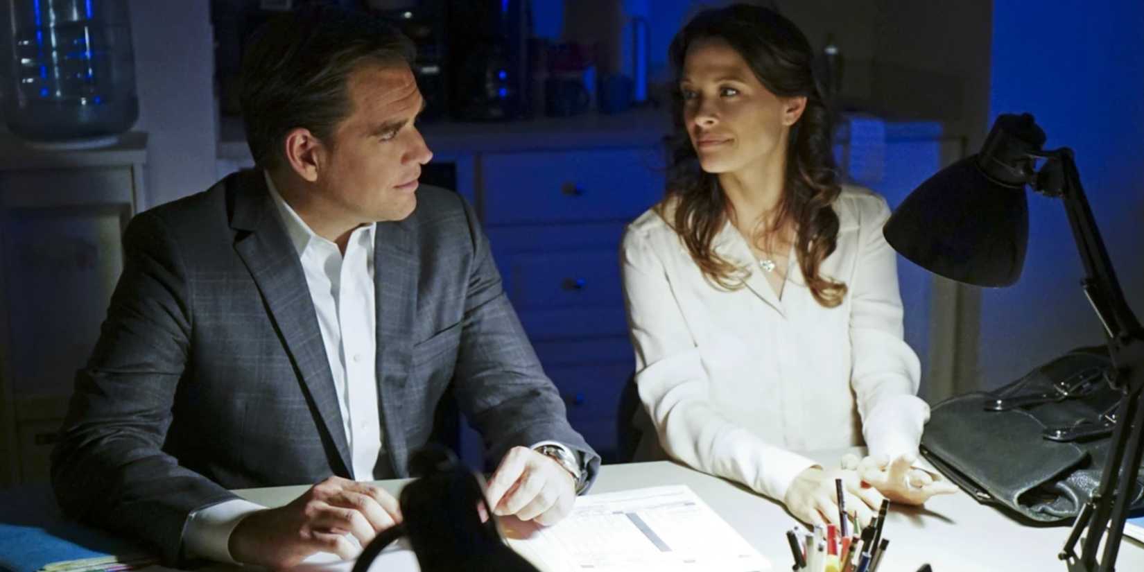 Tony and Jeanne sitting at a desk smiling at one another in NCIS