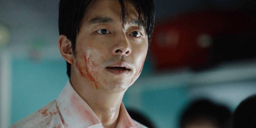 A man with blood on his face looks forward compᴀssionately in a scene from Train to Busan