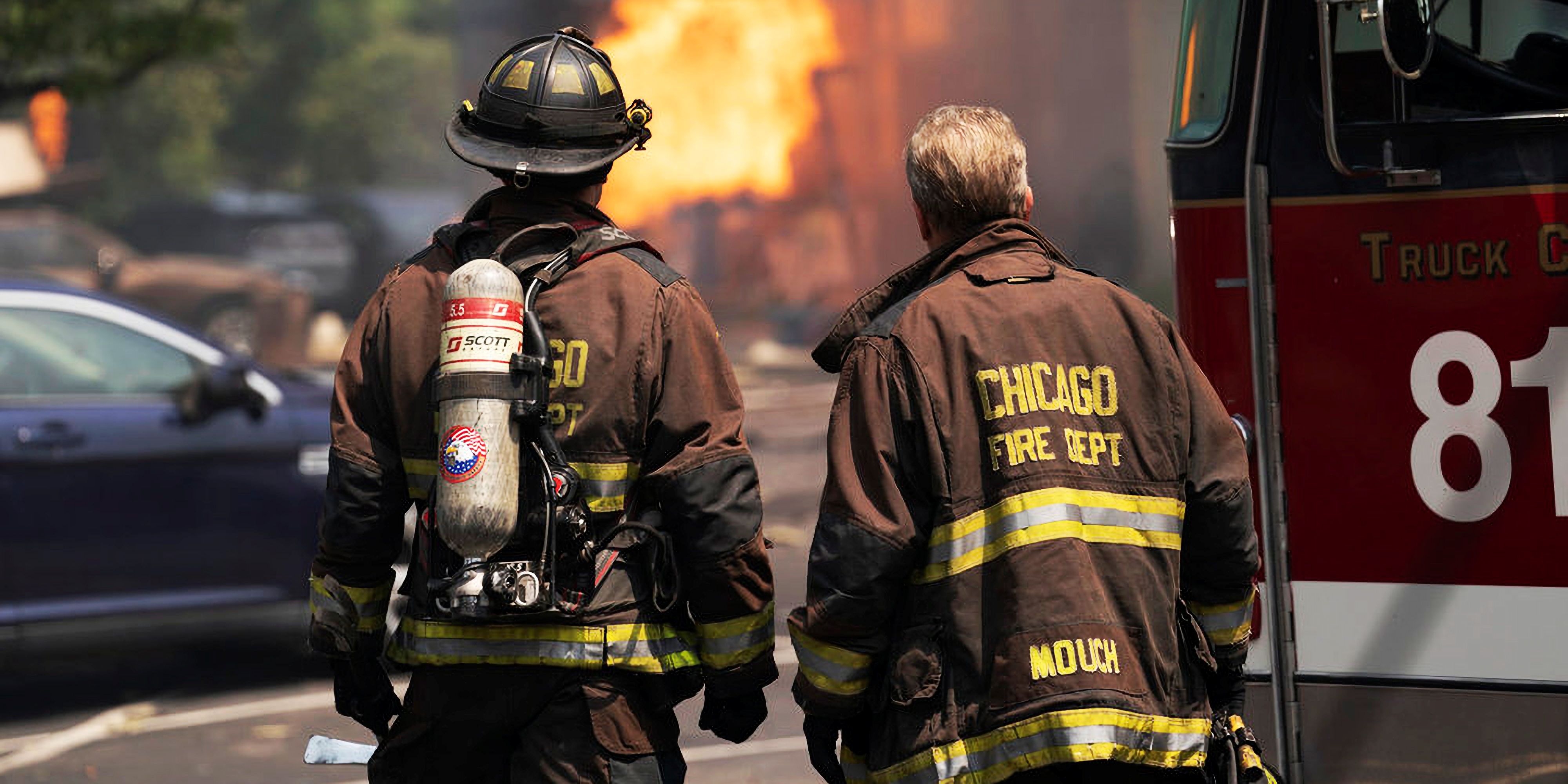 Two firefighters looking at a fire in Chicago Fire season 13