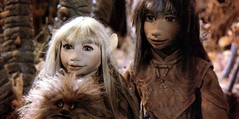Two puppet characters stand side by side in the Dark Crystal