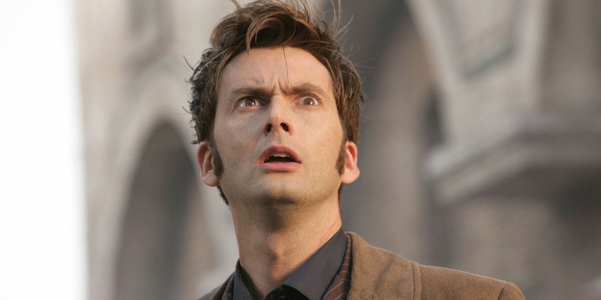 David Tennant as the Tenth Doctor looking shocked as he stares up at the sky in the Doctor Who episode 