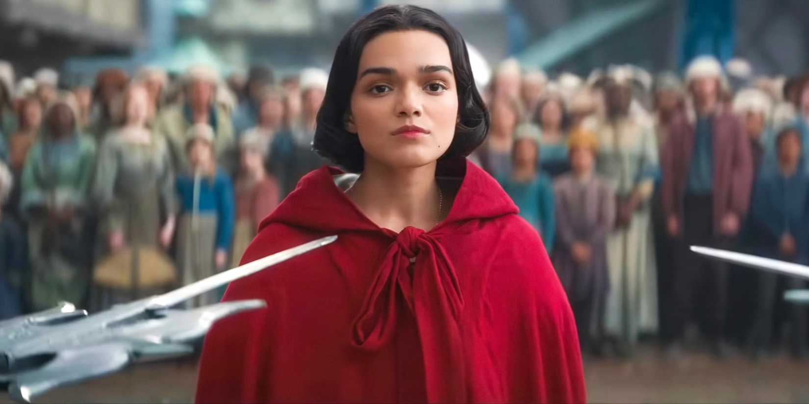 Snow White (Rachel Zegler) standing defiantly while the Evil Queen's guards point their weapons at her in Snow White (2025)