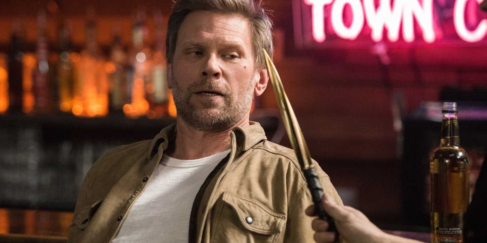 A dagger being held in front of Mark Pellegrino as Lucifer inside of a bar in Supernatural-2
