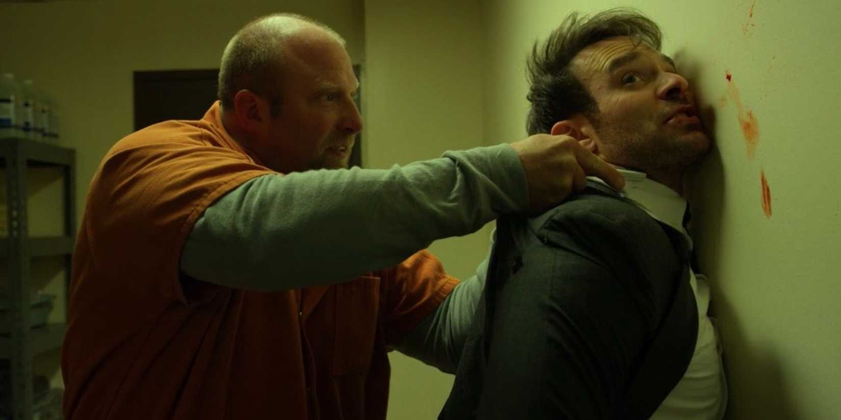 Um prisioneiro segura Matt contra uma parede em Daredevil