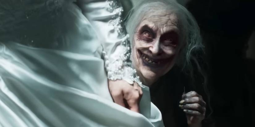 A scary old woman smiling next to Judy in The Conjuring Last Rites