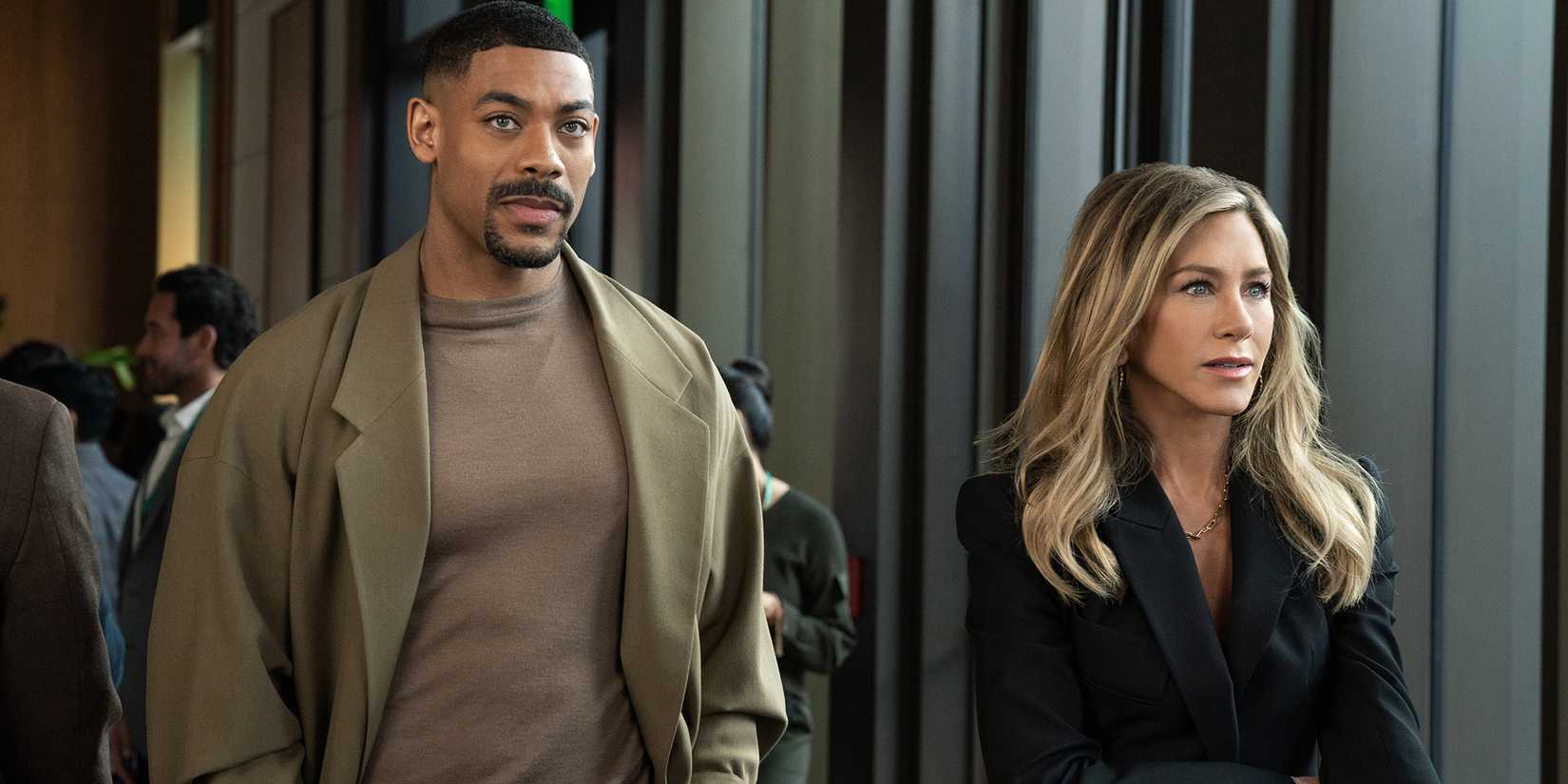 Aaron Pierre and Jennifer Aniston walking next to each other in The Morning Show season 4