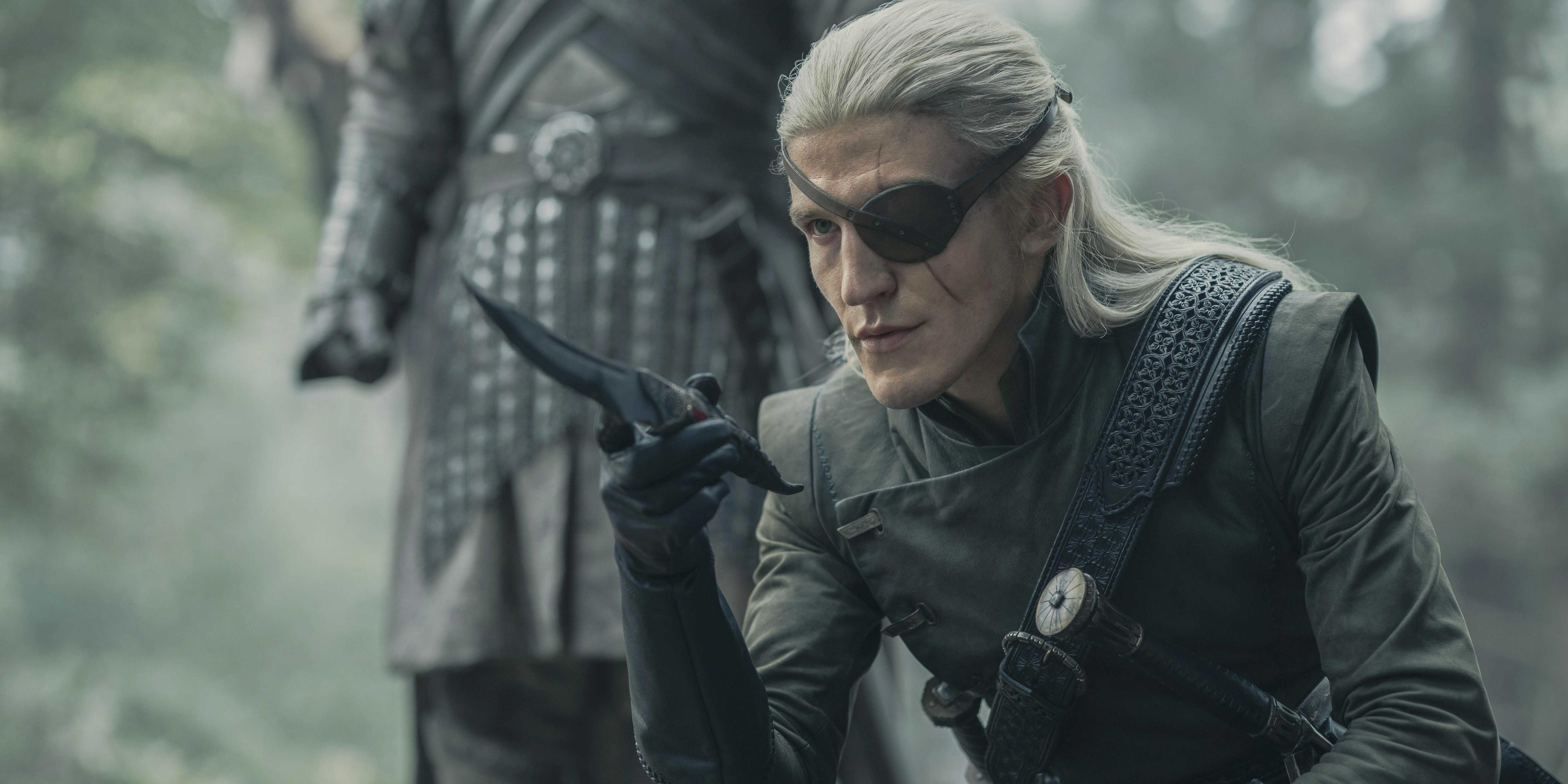 Aemond Targaryen (Ewan Mitchell) kneeling with a knife in House of the Dragon