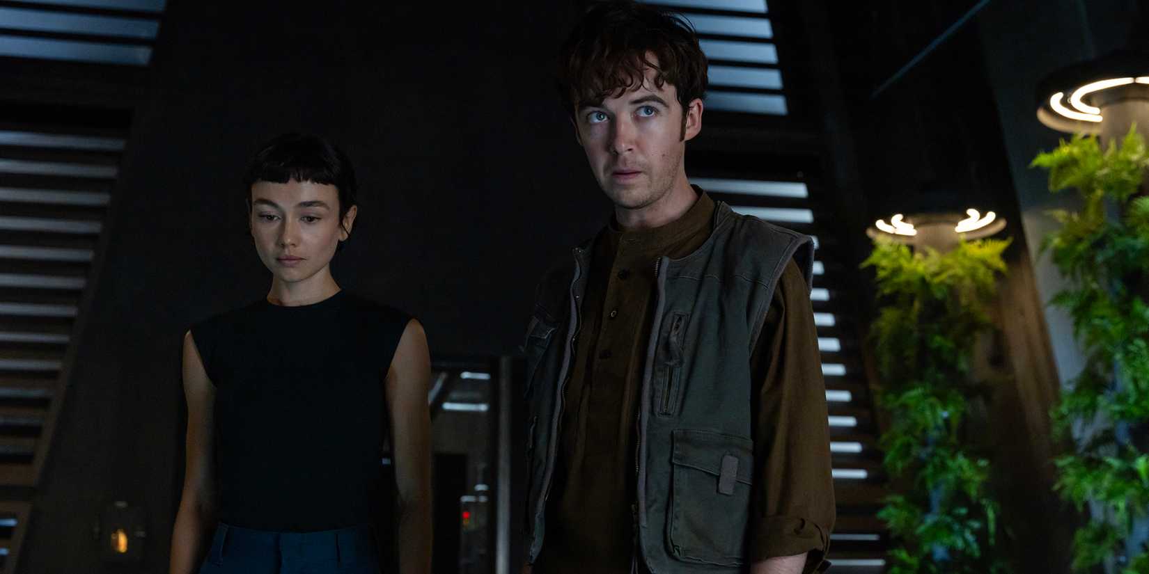 Alex Lawther's Joe looking intensely while Sydney Chandler's Wendy looks distracted behind him in Alien: Earth season 1 episode 8