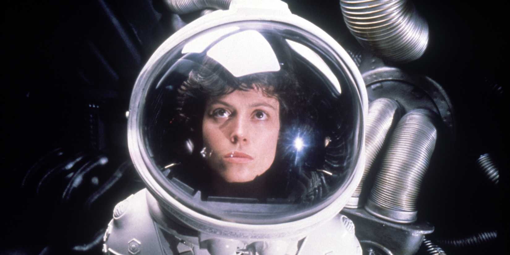 Ellen Ripley wearing a spacesuit and looking up in Alien