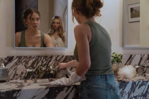 Amanda Seyfried glaring at Sydney Sweeney from behind her in a bathroom mirror in The Housemaid