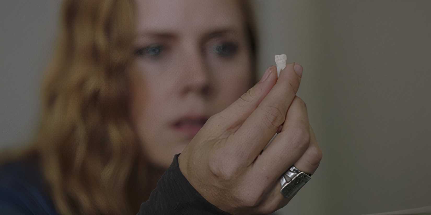 Amy Adams holding a tooth in the final episode of Sharp Objects