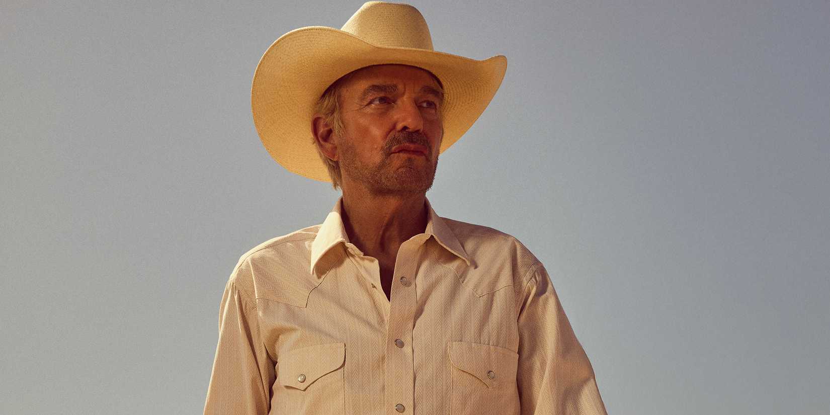 Billy Bob Thornton as Tommy looking stoic while standing in an open environment in Landman season 2
