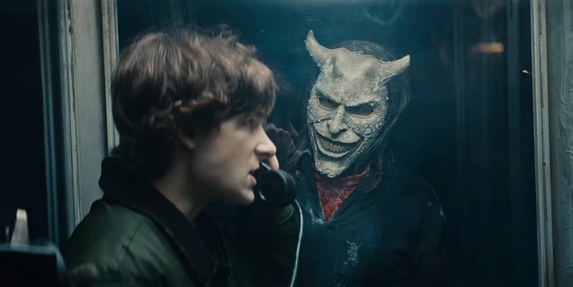 Mason Thames on the phone with Ethan Hawke as The Grabber at the window in The Black Phone 2