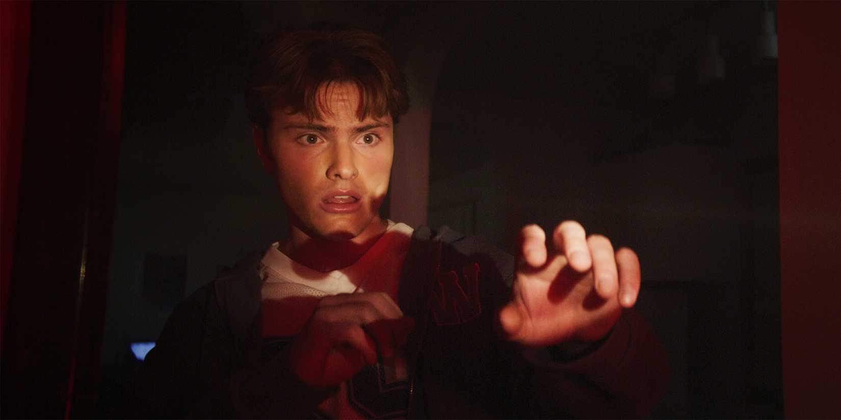 Bryn Samuel's Willis looking worried with his hand up in a dark room in Night of the Reaper