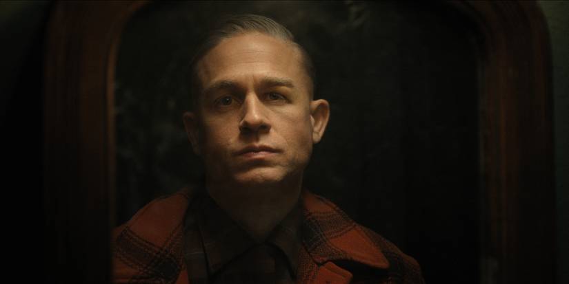 Charlie Hunnam as Ed Gein looking into a mirror in Monster The Ed Gein Story