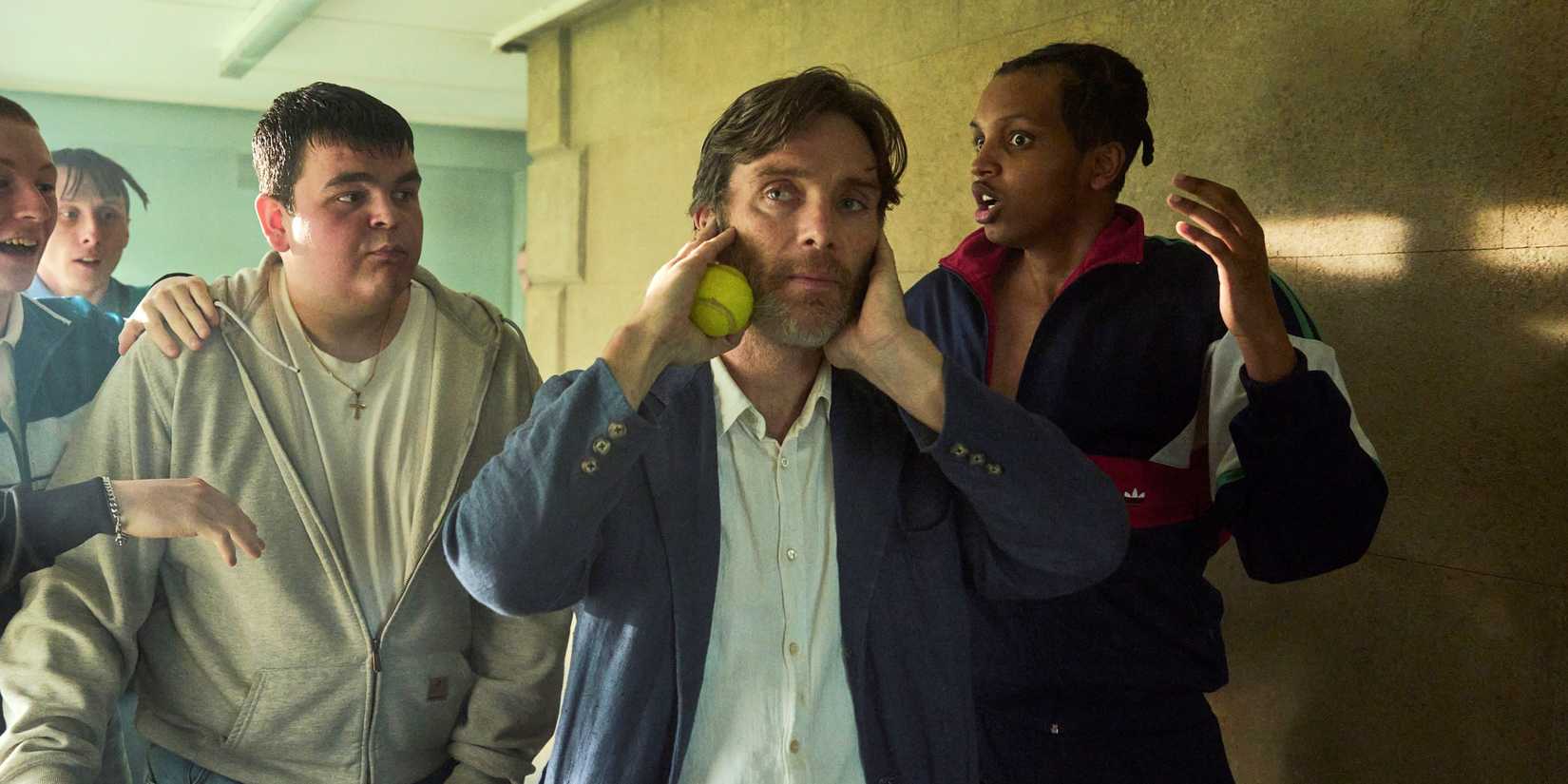 Cillian Murphy covering his ears while holding a tennis ball in Steve