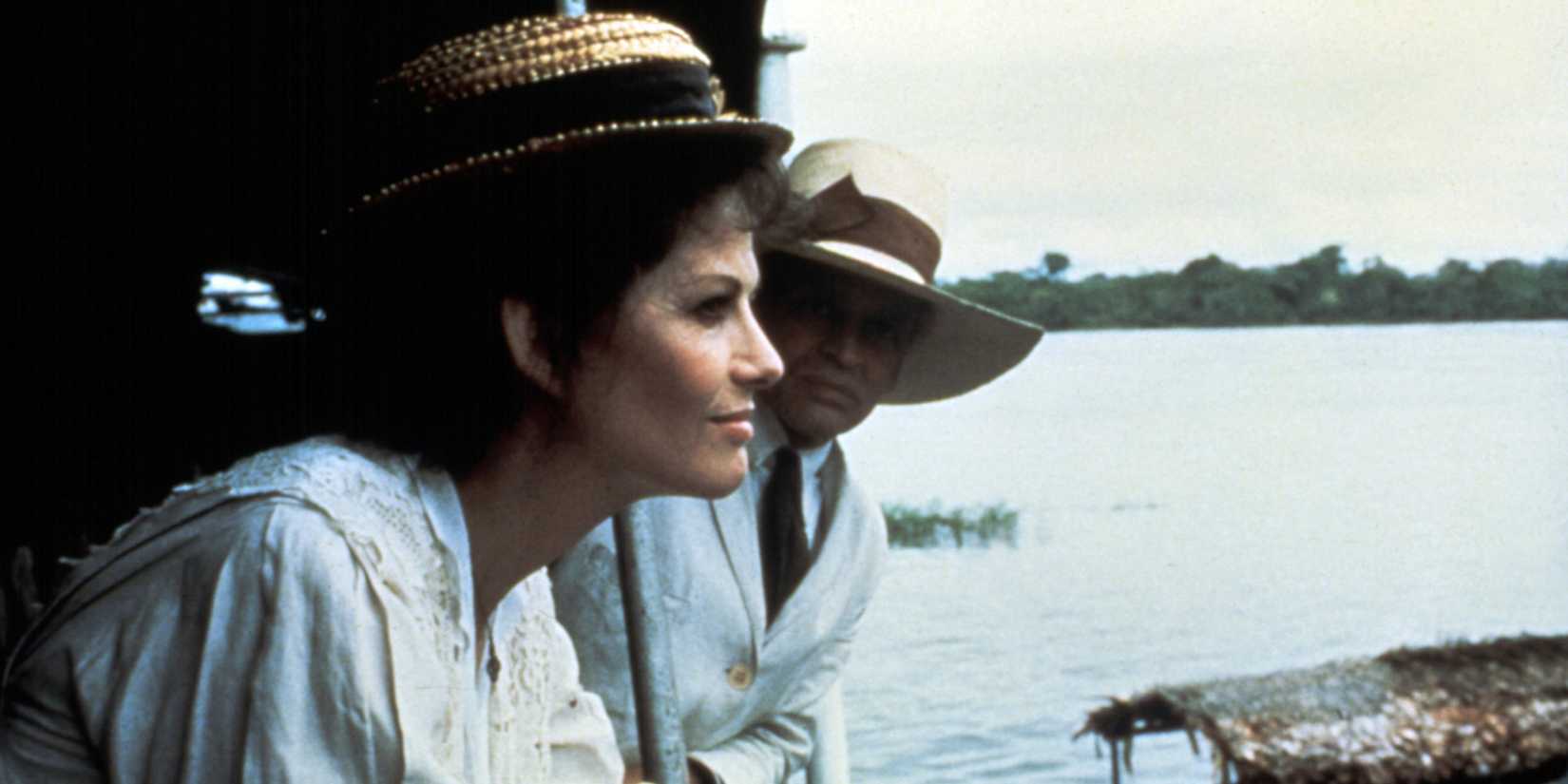 Claudia Cardinale gazes from the deck of a boat as Klaus Kinski looks at her face in a scene from Fitzcarraldo