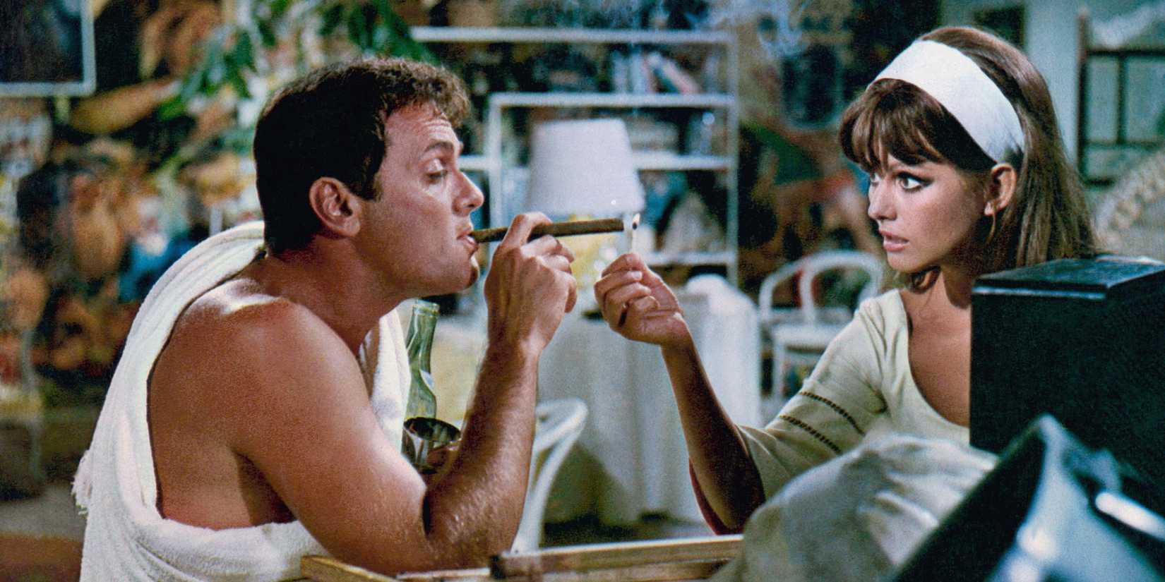 Claudia Cardinale lights Tony Curtis' cigar in a scene from Don't Make Waves