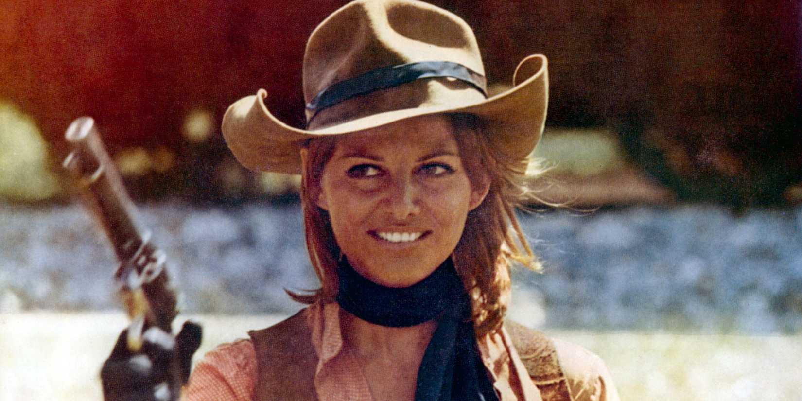 Claudia Cardinale holds a pistol in a scene from The Legend Of Frenchie King